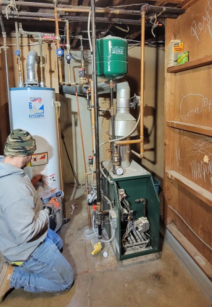 An Eco Temp HVAC technician is beginning his maintenance on a boiler system.
