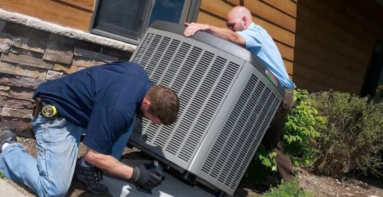 Two Eco Temp HVAC technicians installing a new air conditioning unit.