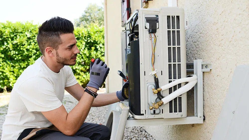 Man diagnosing an AC unit to find out why it is not working properly.