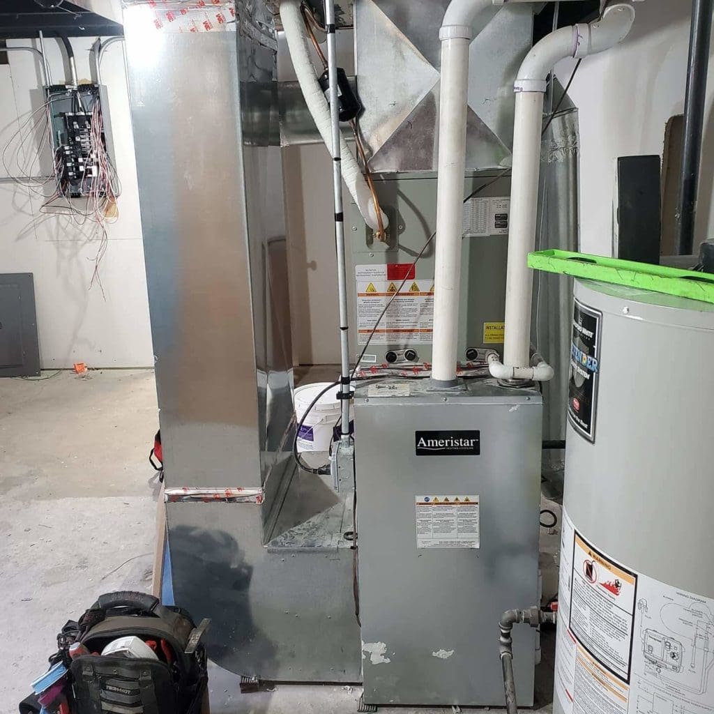 Routine maintenance is performed on an Ameristar furnace. The filter and technician's tools are next to the furnace.