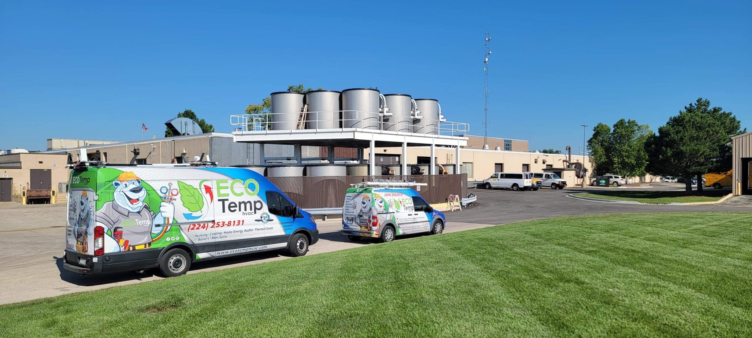 Eco Temp HVAC vans outside of a high school while the technicians are inside repairing their AC units.