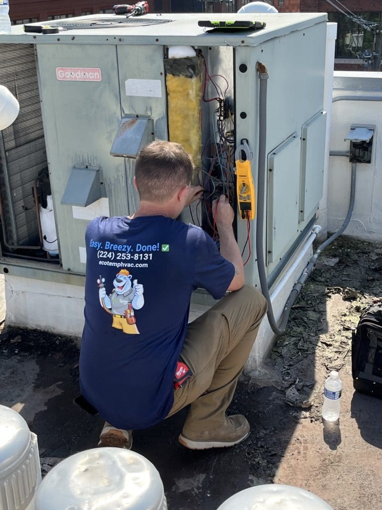 Technician working on a rooftop AC unit in Schaumburg IL