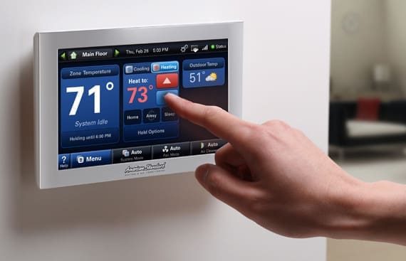 Hand touching American Standard smart thermostat