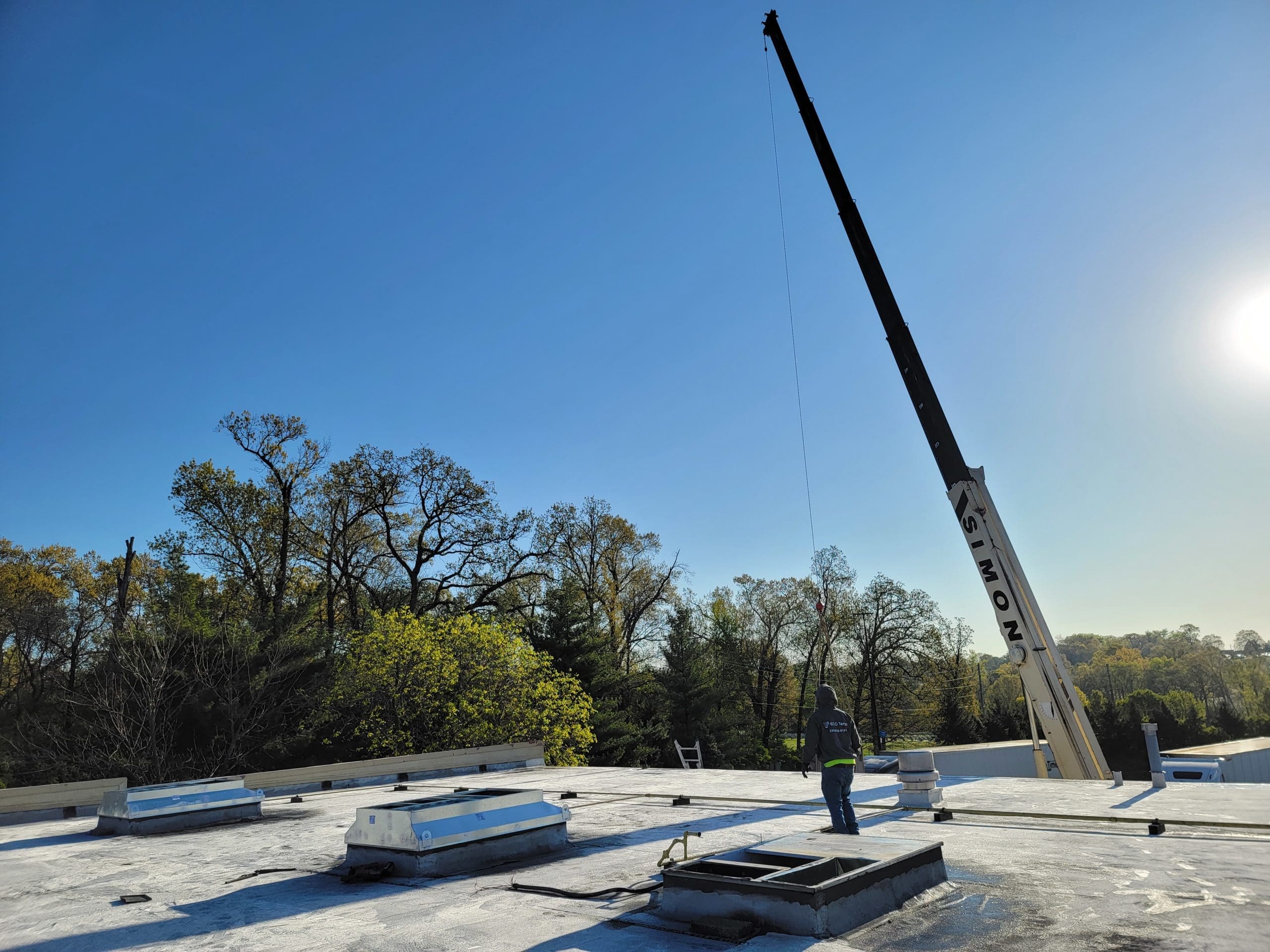 A crane lifting a rooftop AC unit onto the roof of a Chicago business