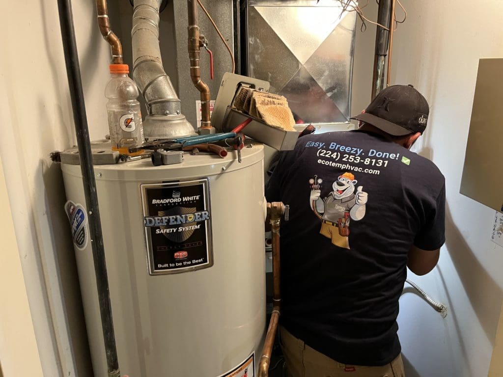 Eco Temp HVAC technician repairing a furnace and water heater in Oak Lawn IL