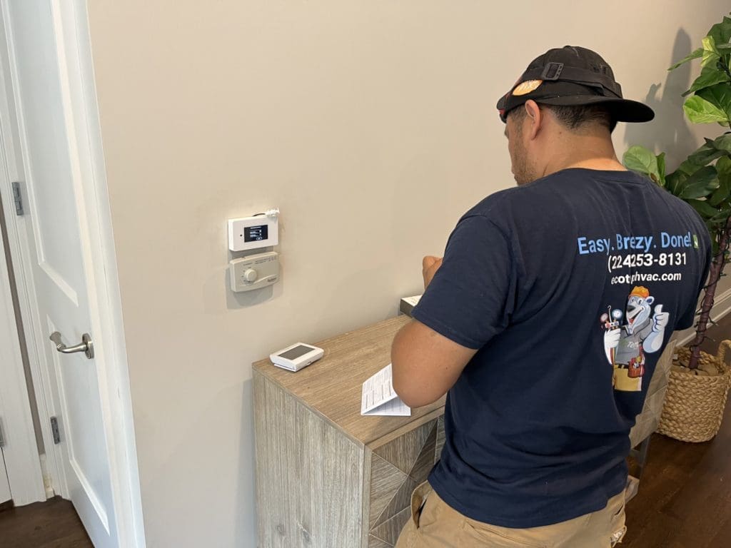 HVAC technician programming a new smart thermostat in Westmont IL.